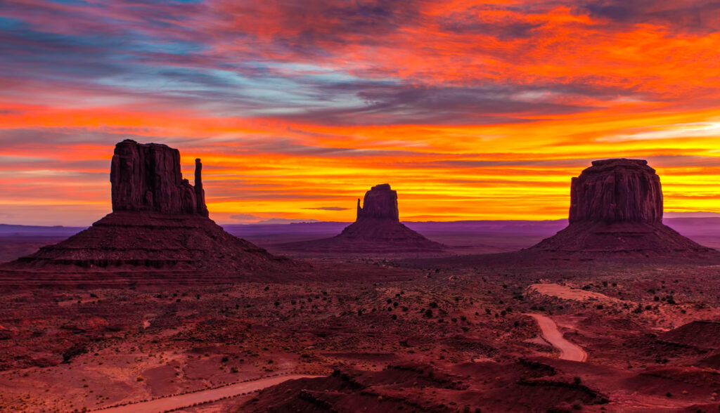 A sunset over the desert with mountains in the background.